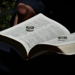 Zwei Eheringe liegen auf einer offenen Bibel.