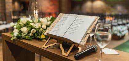 Holzpult mit Eheversprechen, Mikrofon und Blumen bei einer freien Trauungszeremonie.