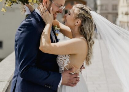 Das glückliche Paar Philipp und Antje umarmt sich an ihrem Hochzeitstag. Die Braut trägt ein wallendes Kleid und einen Schleier.
