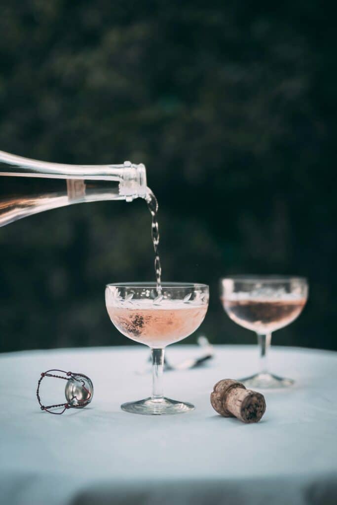 Rosé-Champagner wird bei einer Freien Trauung in Coupé-Gläser gegossen.