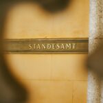 Standesamt-Schild in goldener Schrift auf einer Steinmauer. Das Schild weist auf den Standort des Standesamts hin.