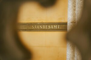 Standesamt-Schild in goldener Schrift auf einer Steinmauer. Das Schild weist auf den Standort des Standesamts hin.