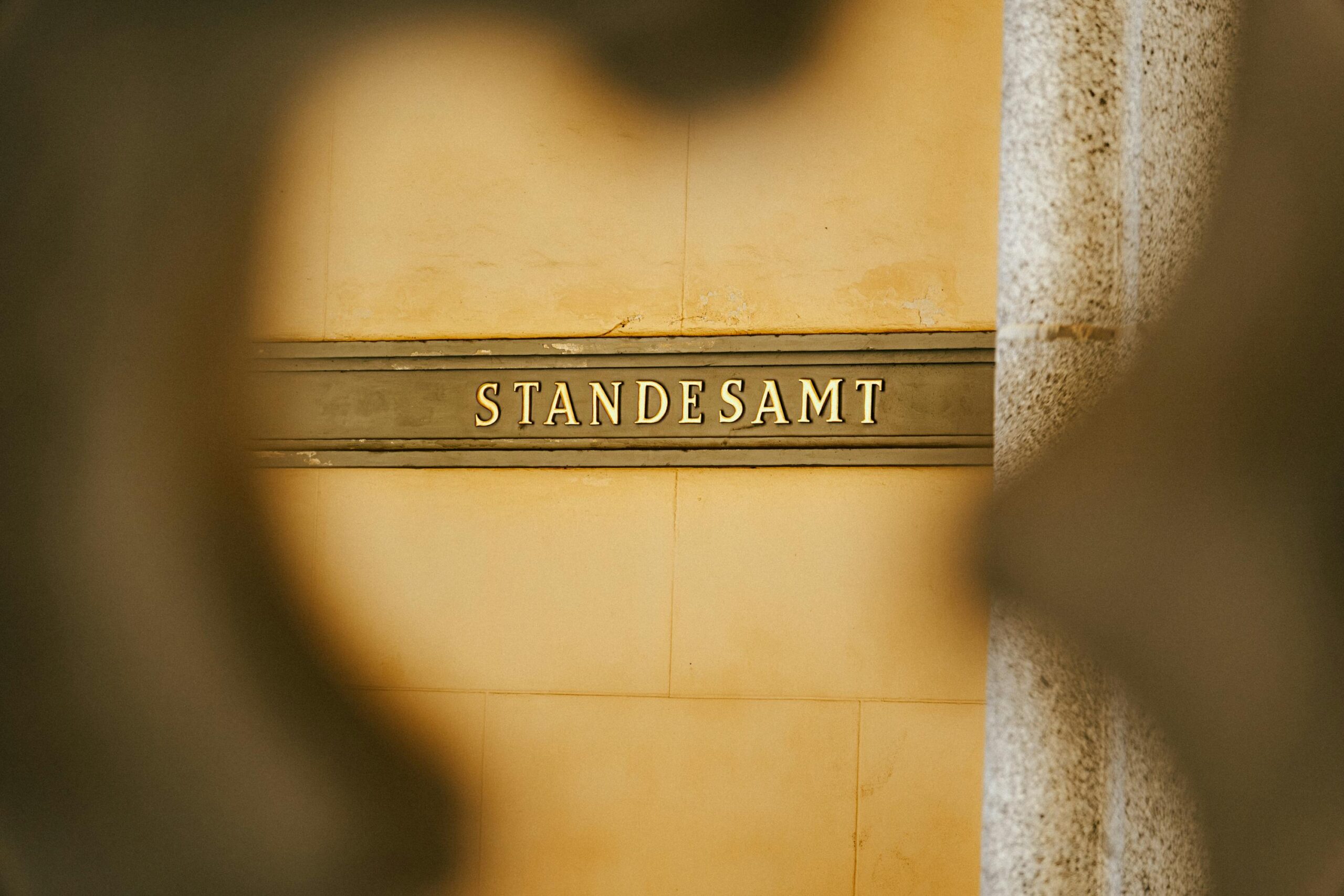 Standesamt-Schild in goldener Schrift auf einer Steinmauer. Das Schild weist auf den Standort des Standesamts hin.