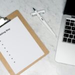 Hochzeits-Checkliste auf Klemmbrett neben Laptop und Stift. Wichtig für die Freie Trauung!