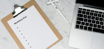 Hochzeits-Checkliste auf Klemmbrett neben Laptop und Stift. Wichtig für die Freie Trauung!